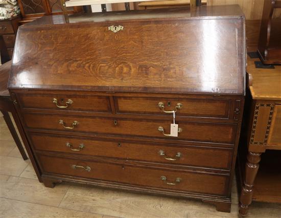 A George III line crossbanded oak bureau, the fitted interior over two short and three long drawers W.122cm